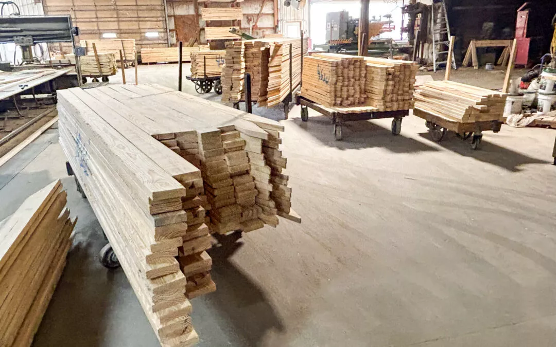Martin's Truss Manufacturing Elkhart IN Stacks of lumber organized in a spacious warehouse with additional wood pallets in the background.