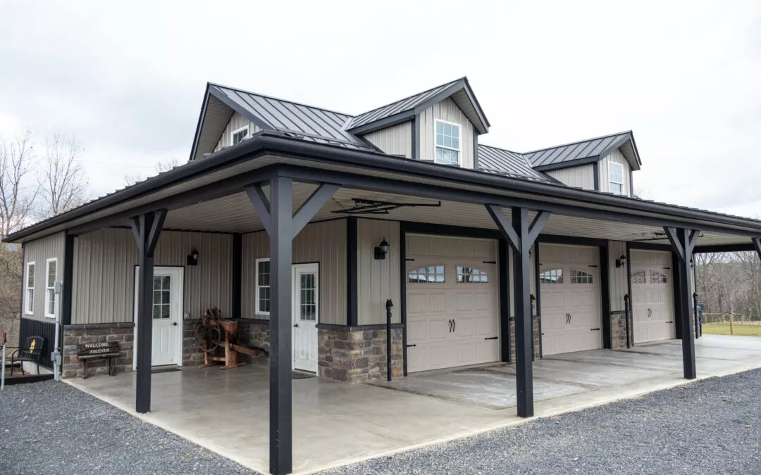 Martin's Trim Forming Millmont, PA A modern garage with three large doors and a covered area featuring a small front porch. The building has a metal roof and is surrounded by a gravel driveway.