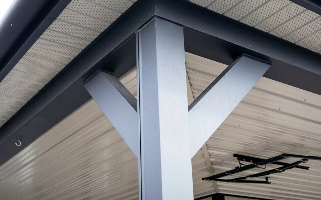 Martin's Trim Forming Millmont, PA Close-up view of a modern metal support beam with a Y-shaped structure, situated under a roof with white metal paneling.