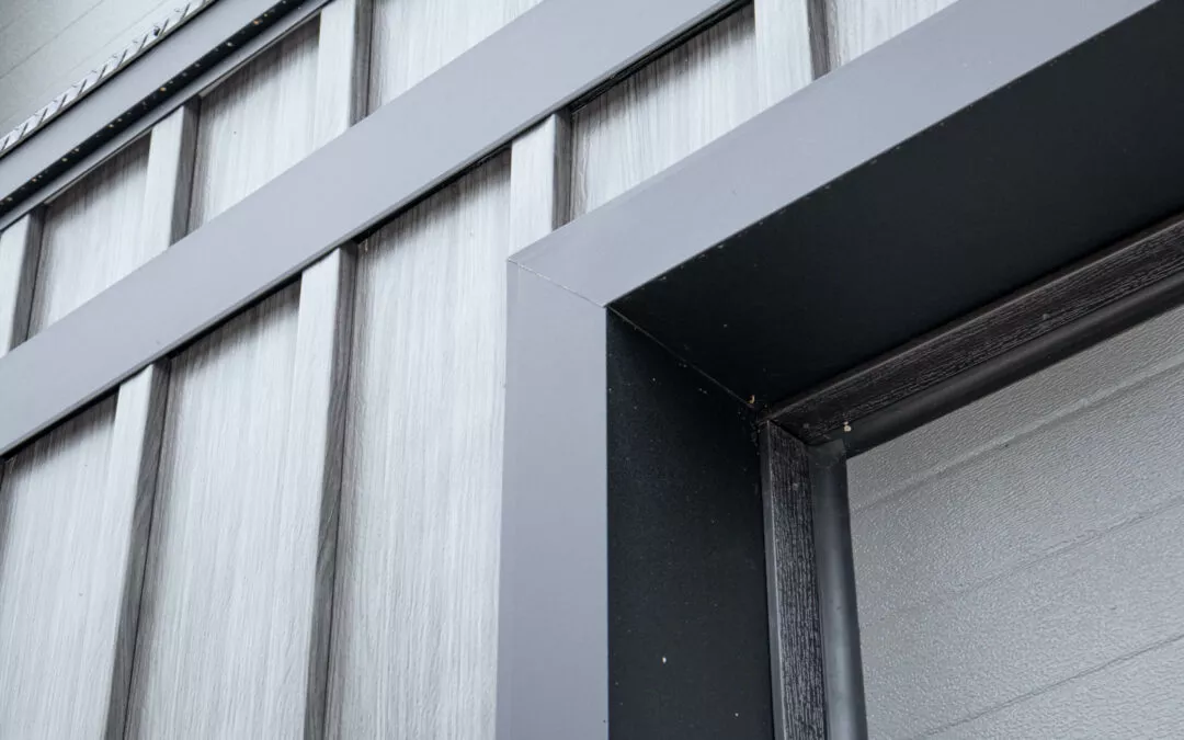 Martin's Trim Forming Millmont, PA Close-up of a building’s exterior, featuring vertical metal cladding and a sharp-angled trim around a doorway. The materials exhibit a sleek, industrial design.