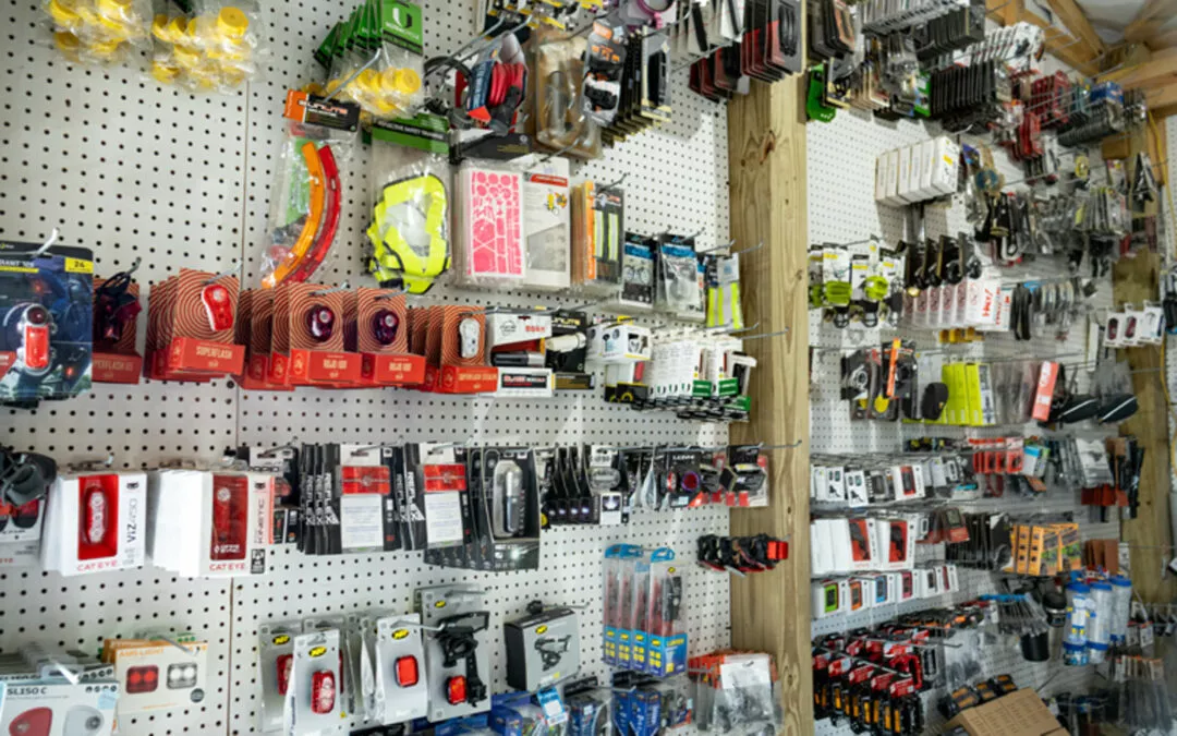 H & H Bicycles Liberty Kentucky A store display featuring various packaged bike accessories, including lights, locks, tools, and other cycling gear, organized on a pegboard wall.
