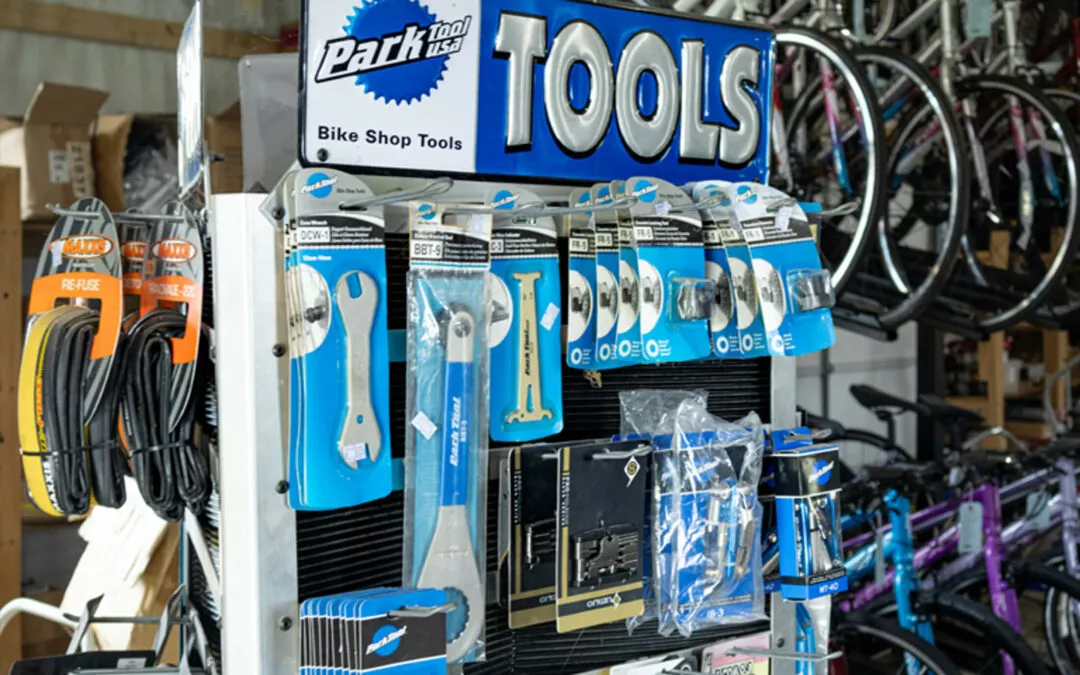 H & H Bicycles Liberty Kentucky Display of Park Tool Co. bike repair tools and accessories, including wrenches, tire levers, and patches, with bicycles in the background.