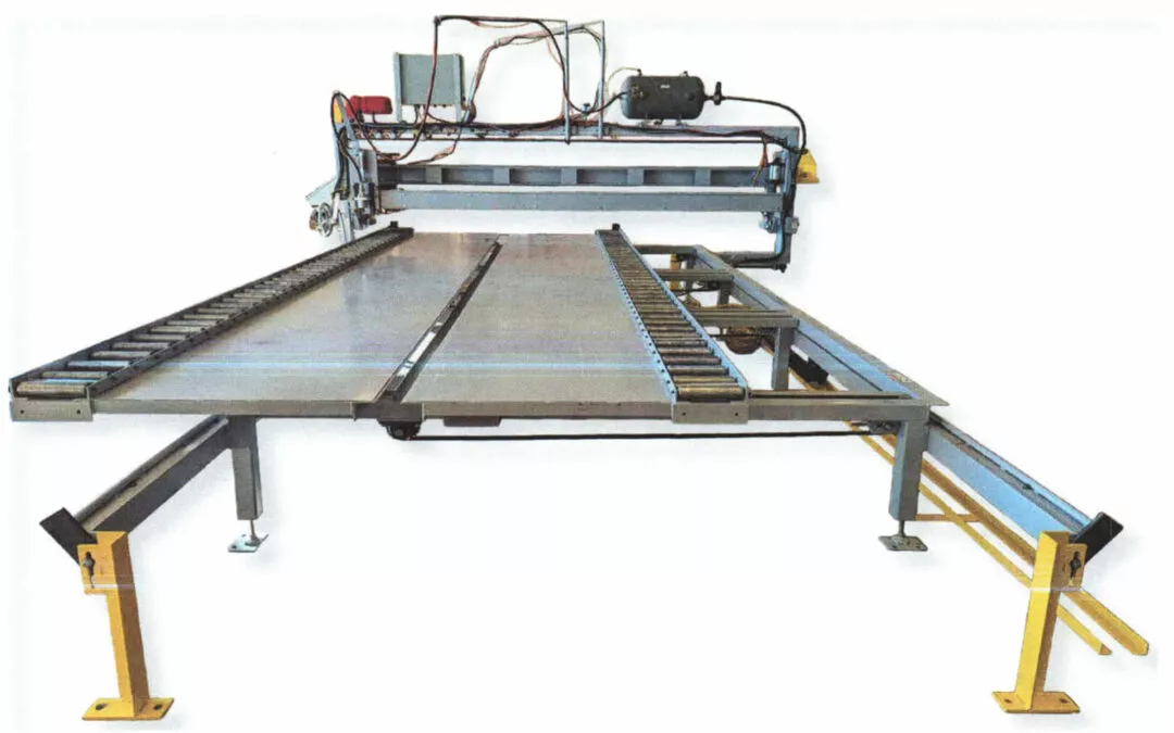 Midstate Lamp LLC Arthur Illinois A large industrial machine with a flat conveyor belt system, metal framework, and multiple fixed mechanical components, likely used for manufacturing or assembly line processes.