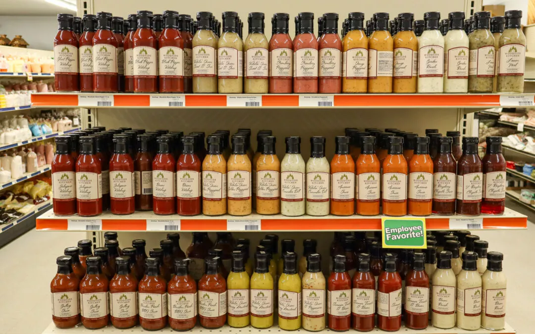 Lakeside Country Store Mishicot, Wisconsin Shelves stocked with various flavors of salad dressings and sauces in bottles at a grocery store, with a green sign marked "Employee Favorite" on the middle shelf.