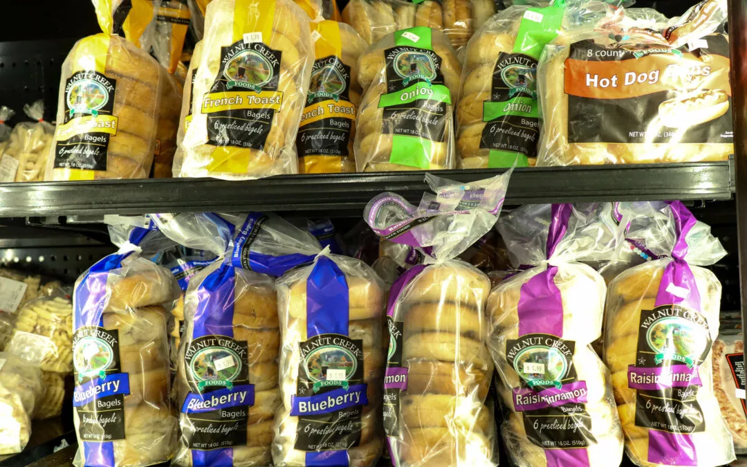 Lakeside Country Store Mishicot, Wisconsin A variety of packaged bagels and hot dog buns displayed on grocery store shelves, including flavors like French toast, onion, blueberry, and raisin and cinnamon.