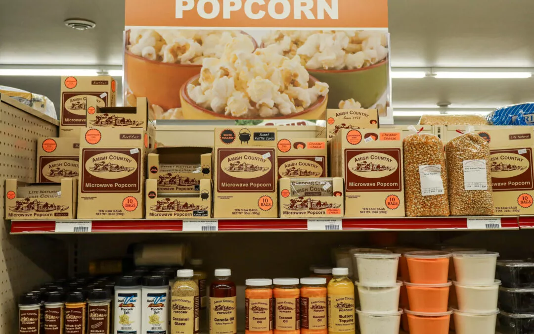 Lakeside Country Store Mishicot, Wisconsin A supermarket shelf displays a variety of Amish Country microwave popcorn products, popcorn kernels, seasonings, and toppings below a sign reading "Popcorn.