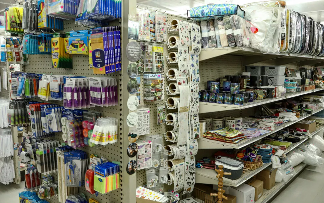 Brubaker's Sewing & Furniture Withee, WI A store aisle filled with various stationery, stickers, and craft supplies displayed on shelves and racks.
