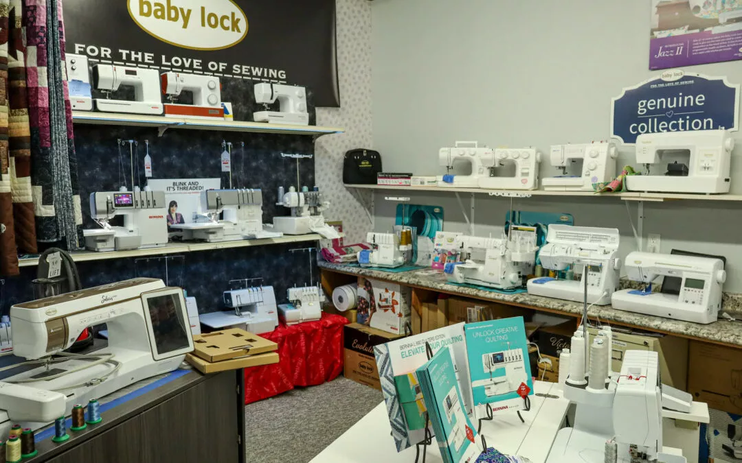 Brubaker's Sewing & Furniture Withee, WI A display of various sewing machines in a store. Shelves hold multiple models labeled "baby lock," along with brochures, thread spools, and sewing accessories.
