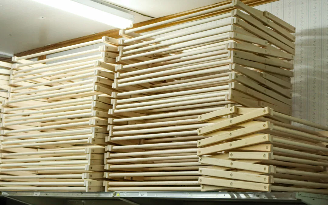 Brubaker's Sewing & Furniture Withee, WI Wooden drying racks stacked on shelves in a room with fluorescent lighting.