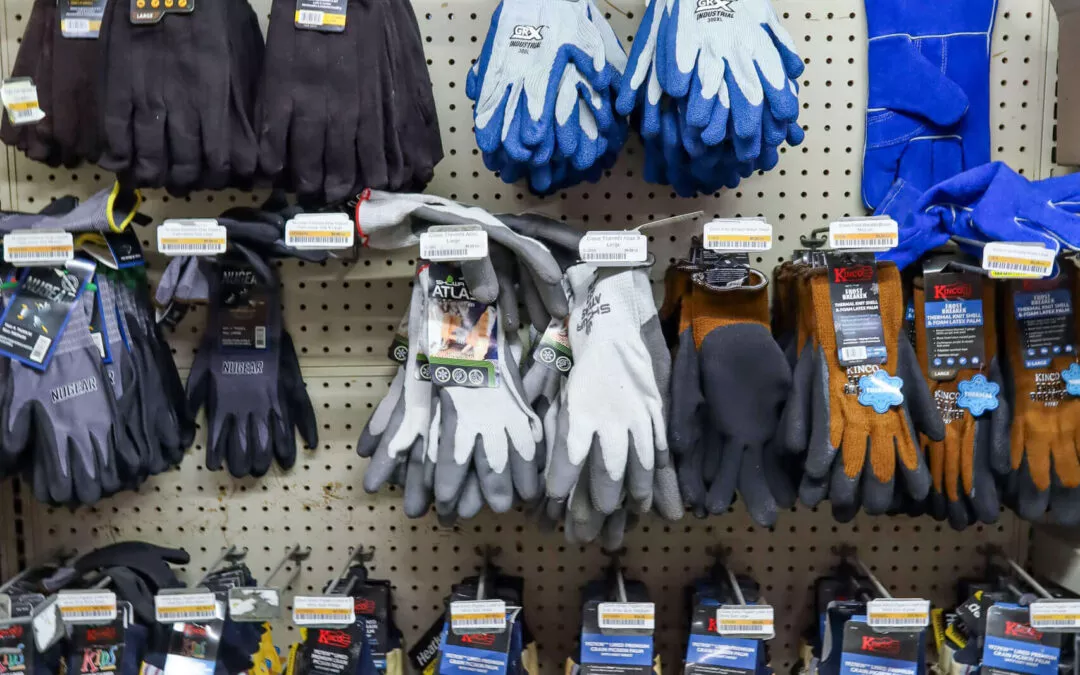 Chippewa Vallaey Dairy Supply Stanley, WI A display of various work gloves with different colors and brands hanging on a pegboard.