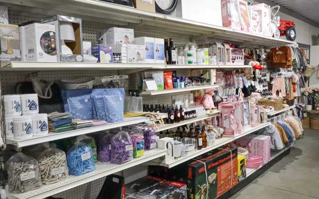 The Country Barn Middlebury Indiana Store aisle with shelves displaying various products including toiletries, blankets, toys, baby items, and home goods in a retail setting.