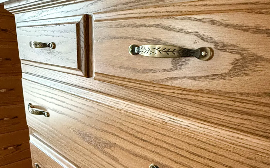 Sugar Valley Chair Shop Loganton, PA Close-up of a wooden dresser with three drawers, featuring ornate metal handles with leaf patterns.