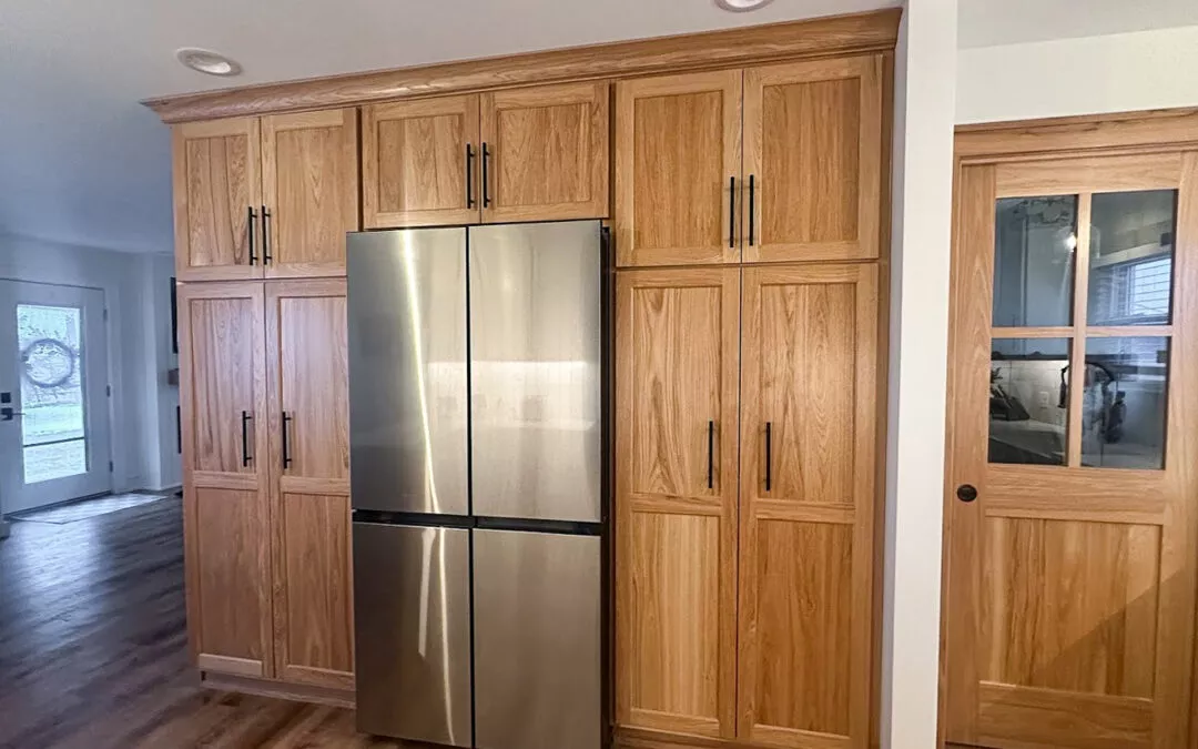 The Woodpecker Sullivan, Illinois A kitchen features a stainless steel refrigerator surrounded by wooden cabinets and a sliding door on the right.