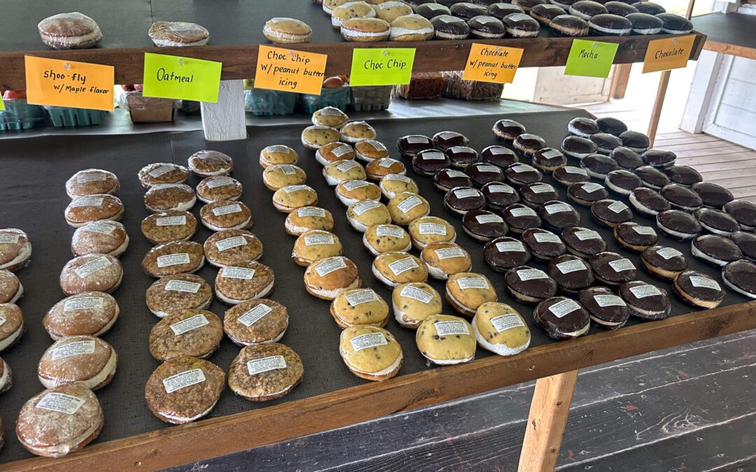 Chub Run Chemical Free Organic Produce Mill Hall PA Rows of packaged whoopie pies and cookies are displayed on wooden shelves, each row labeled with flavors such as oatmeal, chocolate chip, and chocolate.