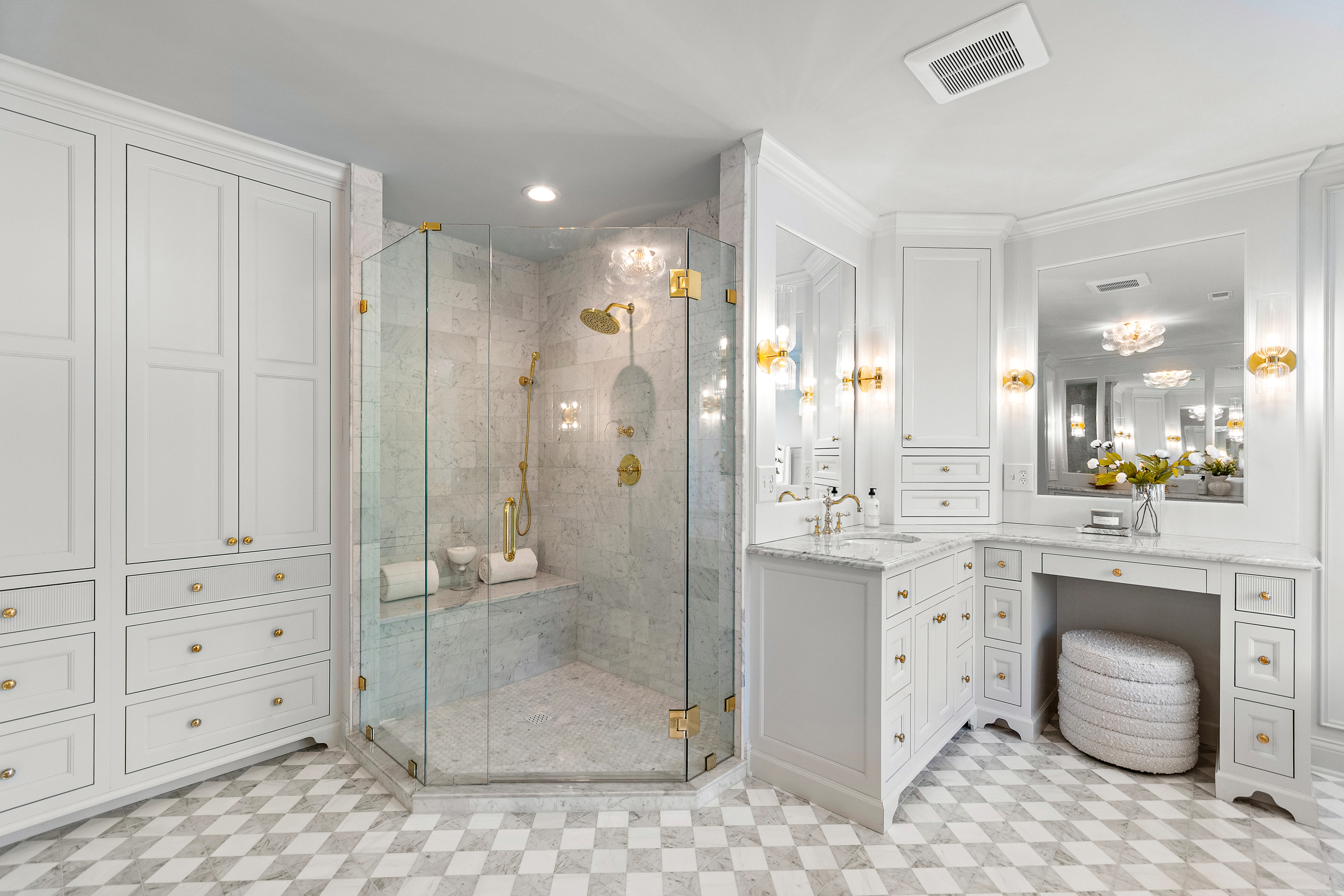 Kenrose Kitchen Kabinets Cabinetry Arthur IL Elegant white bathroom with gold accents, glass shower enclosure, built-in cabinets, marble countertop, vanity area, and checkered tile flooring.