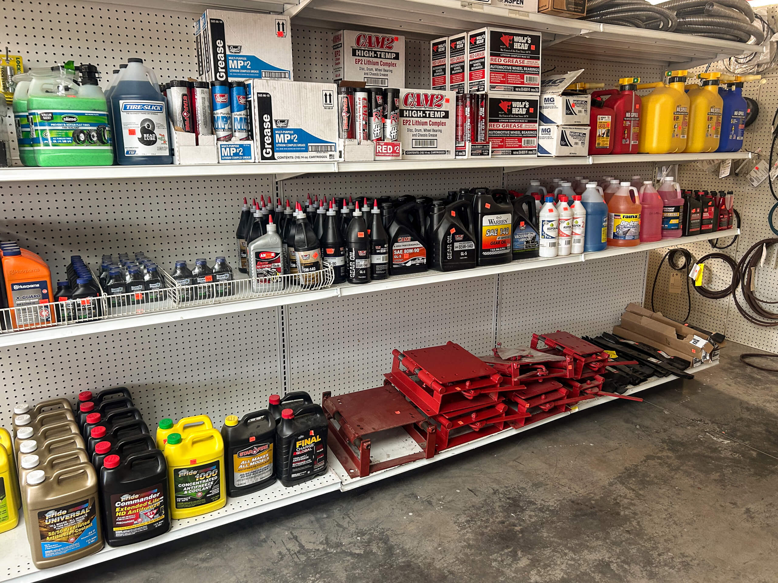 Buel Road Small Engine Repair Canajoharie, NY Shelves stocked with various automotive fluids, oil containers, and maintenance supplies in a store or workshop.