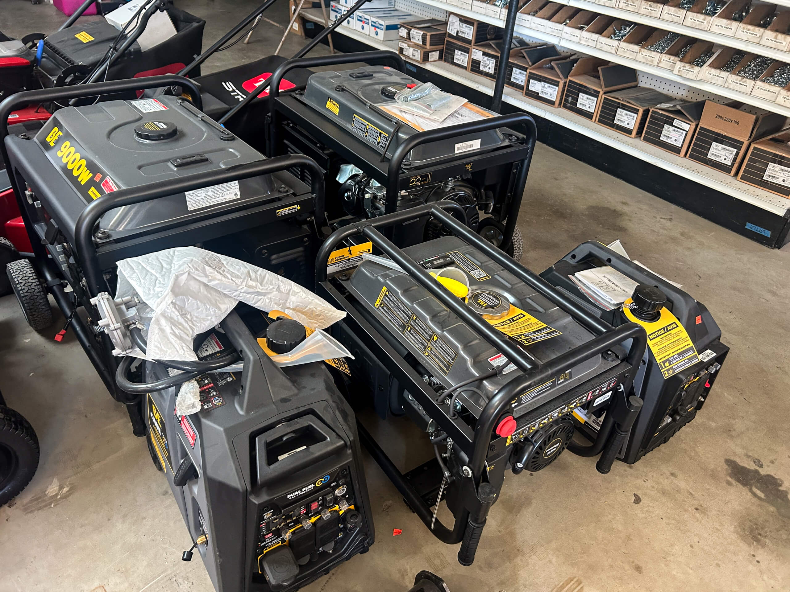 Buel Road Small Engine Repair Canajoharie, NY Several portable generators of various sizes are displayed on a concrete floor in a store, with shelves of small boxed items in the background.