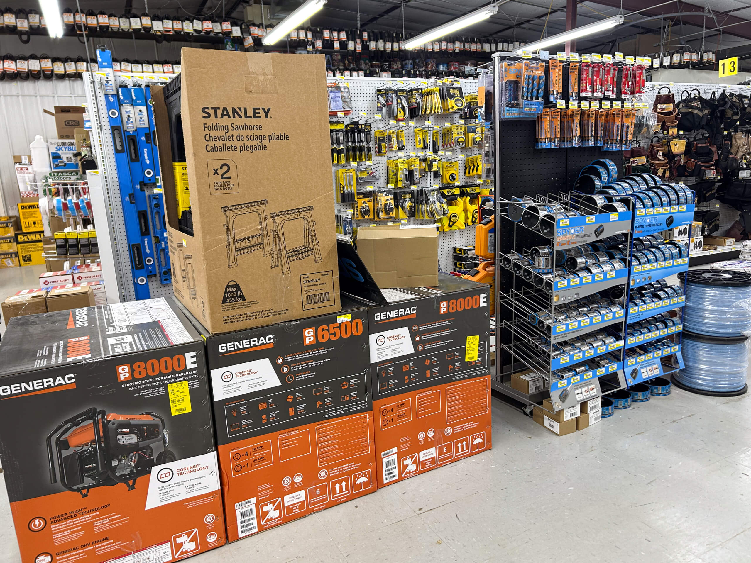 Benny's Hardware Barnett MO Shelves in a hardware store displaying generators, toolboxes, hand tools, and various accessories such as tape rolls and work belts.
