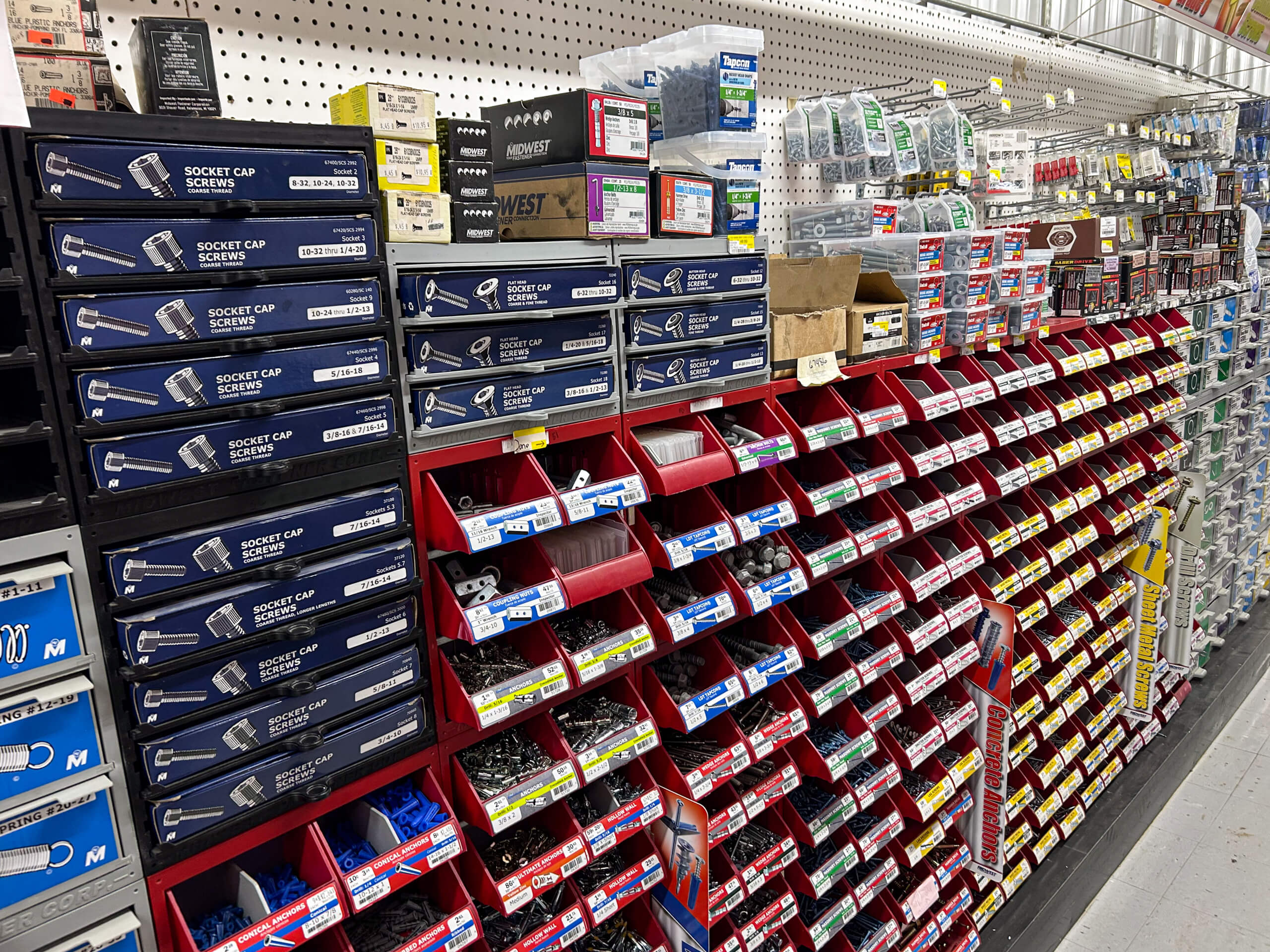 Benny's Hardware Barnett MO Shelves and bins in a hardware store stocked with socket cap screws, fasteners, and various small hardware parts organized by type and size.