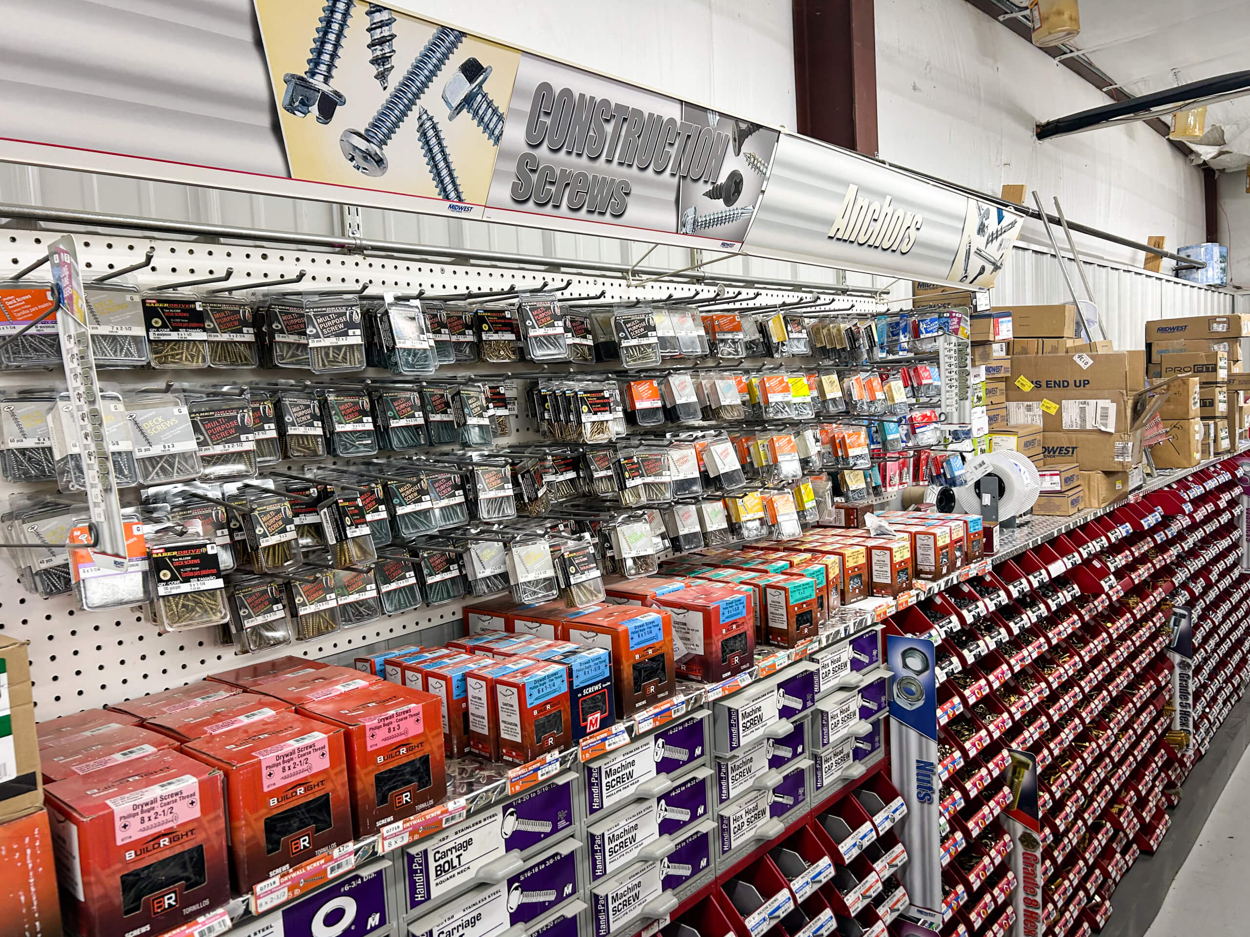 Benny's Hardware Barnett MO A hardware store aisle displays various construction screws and anchors in organized packages on shelves and pegboards.