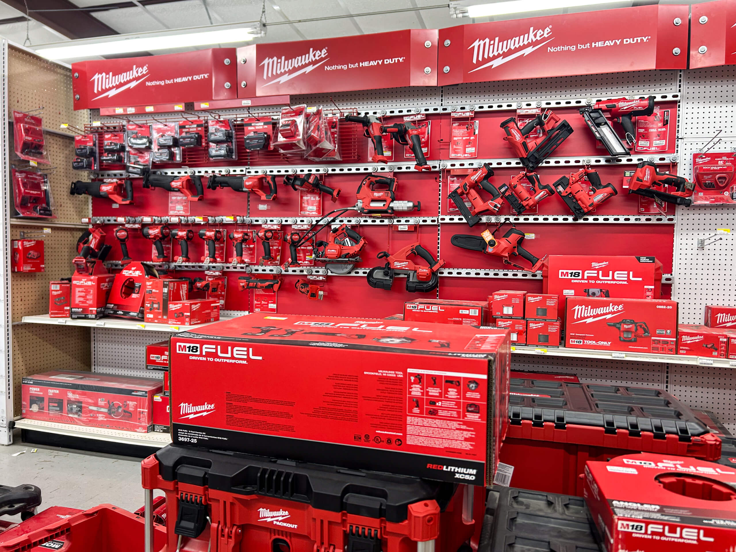 Benny's Hardware Barnett MO Display of Milwaukee power tools and accessories on shelves in a store, featuring red packaging and various tool models organized on hooks and shelves.