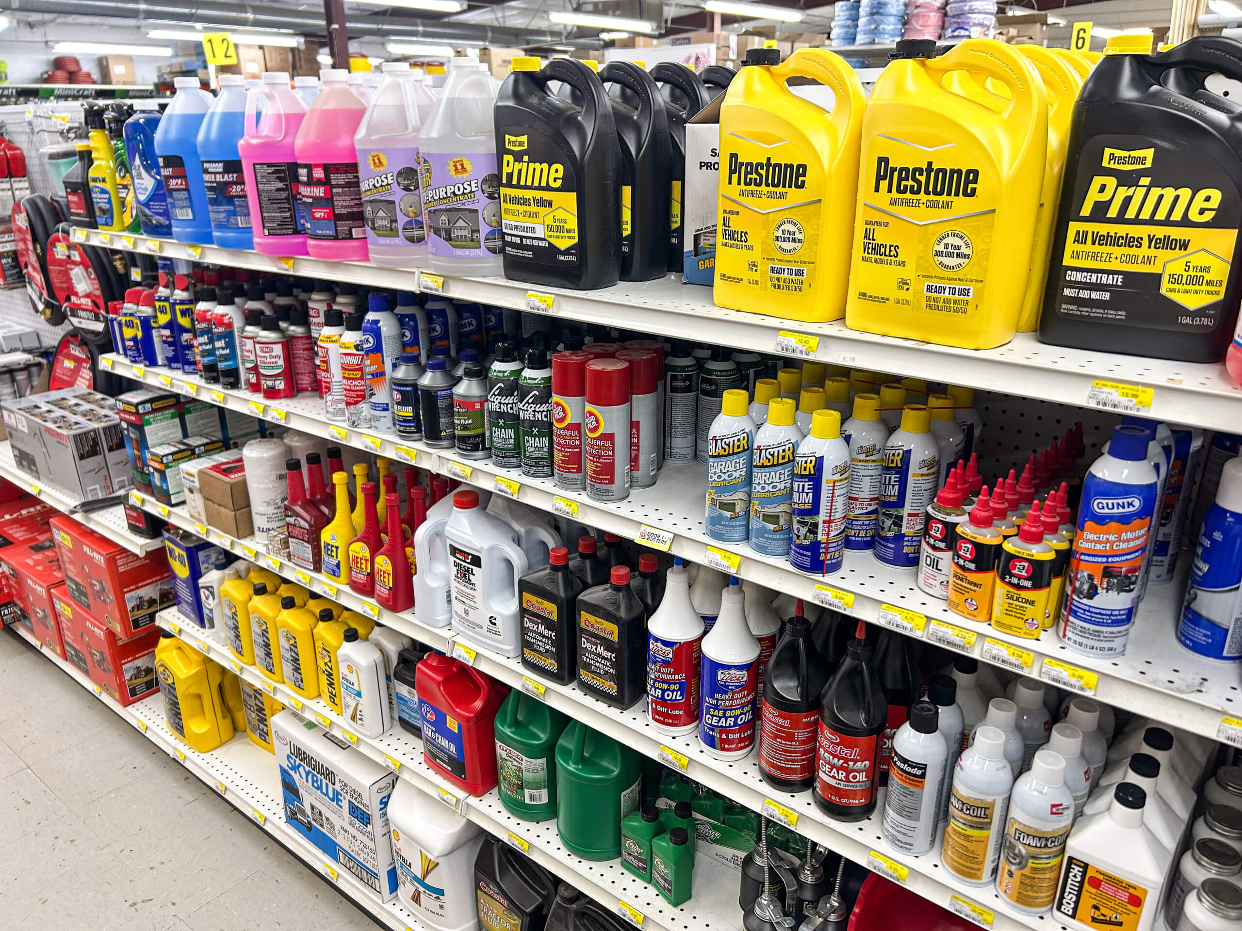 Benny's Hardware Barnett MO Shelves stocked with various automotive fluids and chemicals, including antifreeze, coolant, oil, and fuel additives, displayed in a store aisle.