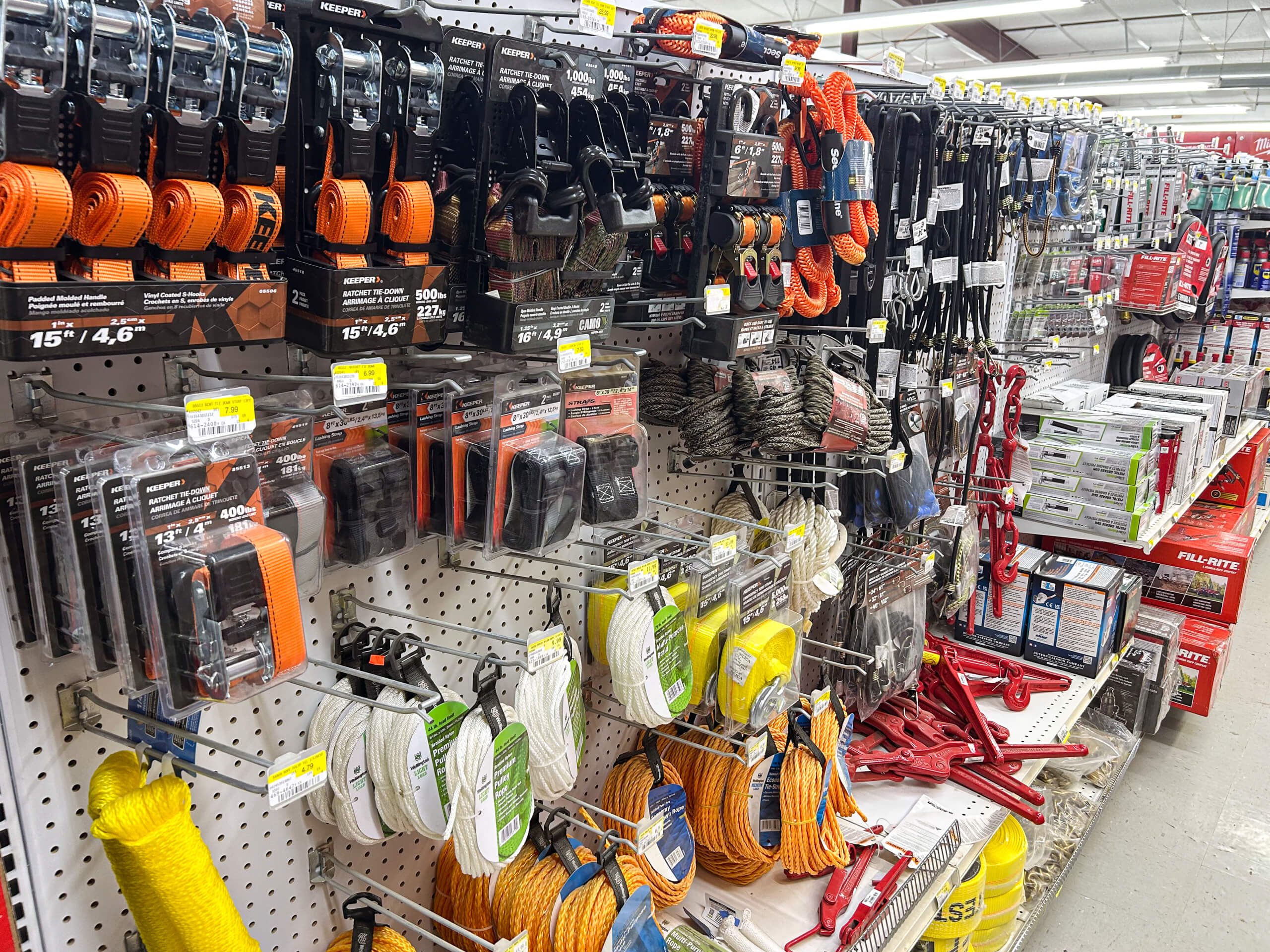 Benny's Hardware Barnett MO A store aisle shelf displays various ropes, tie-down straps, cables, and related hardware items in different colors and packaging.