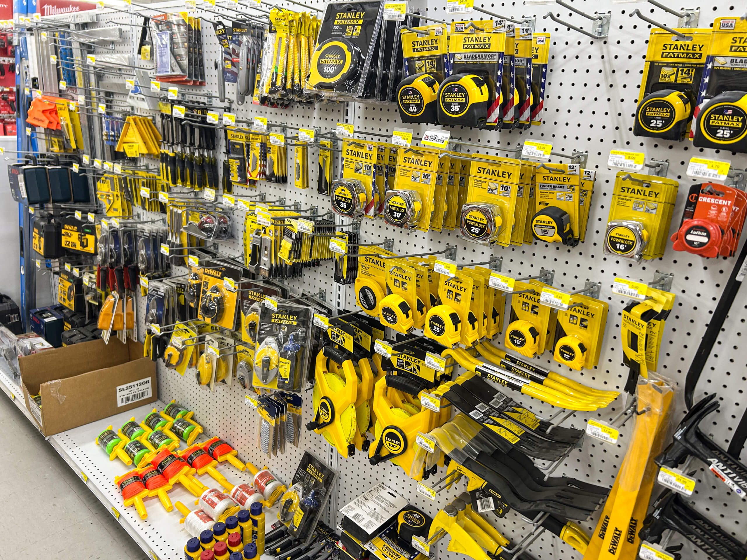 Benny's Hardware Barnett MO Various Stanley brand hand tools, including tape measures, pliers, cutters, and screwdrivers, displayed on a pegboard wall in a hardware store aisle.