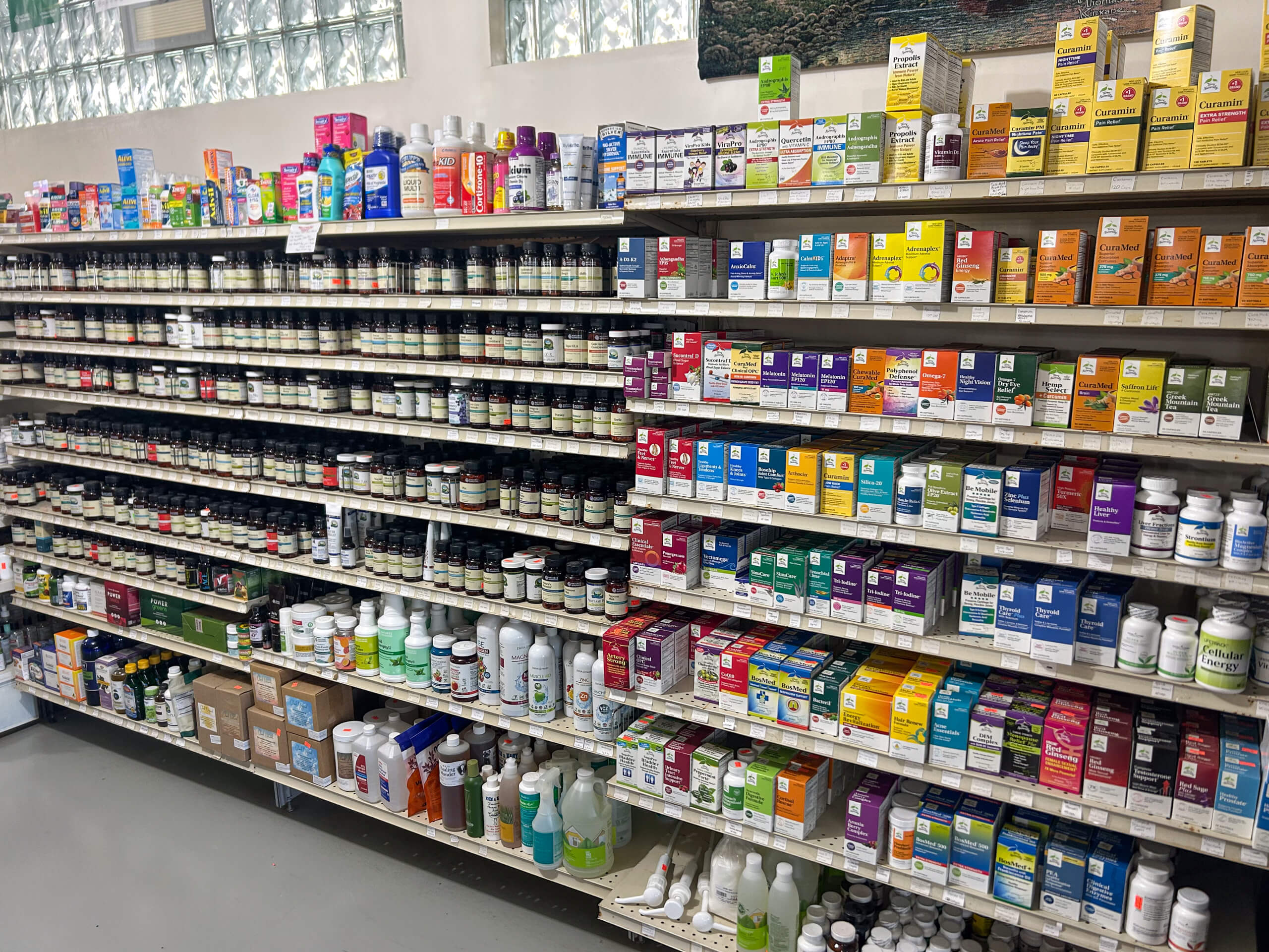 Miller's Country Store Grabill IN Shelves stocked with various vitamins, supplements, and wellness products in bottles and boxes at a pharmacy or health store.