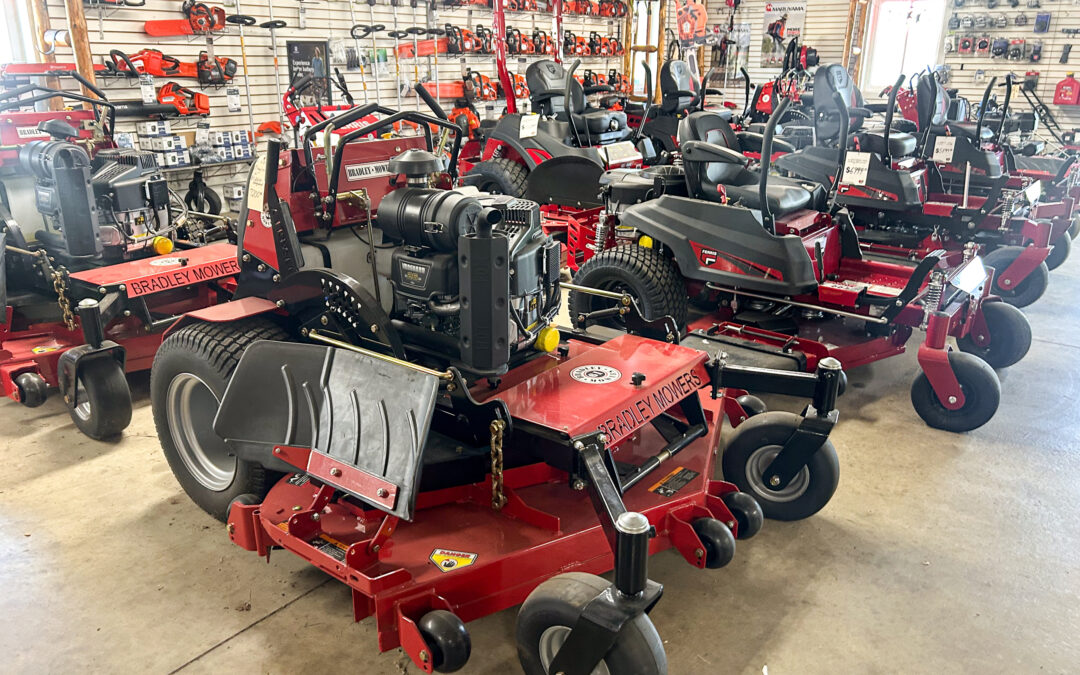 Miller's Sales & Service Centerville, MI Several riding lawn mowers and power equipment are displayed inside a showroom, surrounded by various tools and accessories on wall racks.