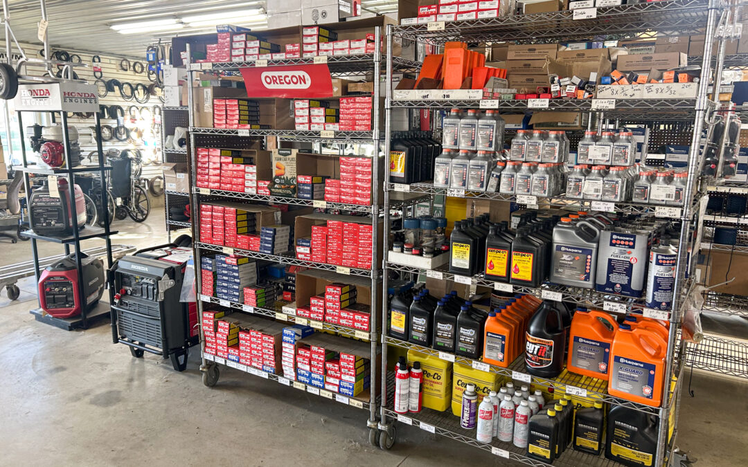 Miller's Sales & Service Centerville, MI Shelves stocked with various automotive and machinery parts, oils, and fluids in a well-lit workshop or supply store.