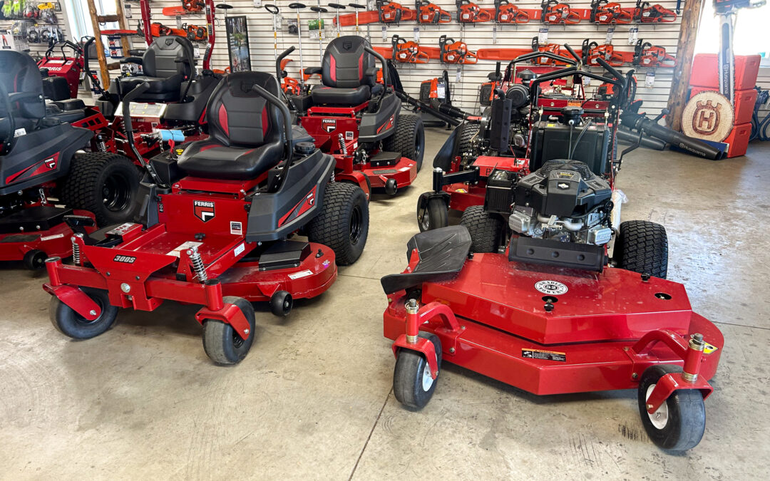 Miller's Sales & Service Centerville, MI Several red commercial lawn mowers and outdoor power equipment are displayed indoors on a showroom floor, with accessories hanging on the wall in the background.