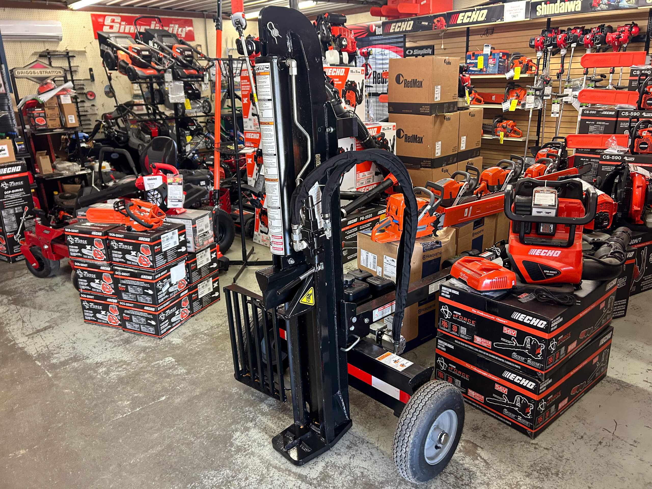 11.4.25 AK Small Engines Gallery 2-6 A hardware store displays stacked boxes of Echo outdoor power tools, with various equipment