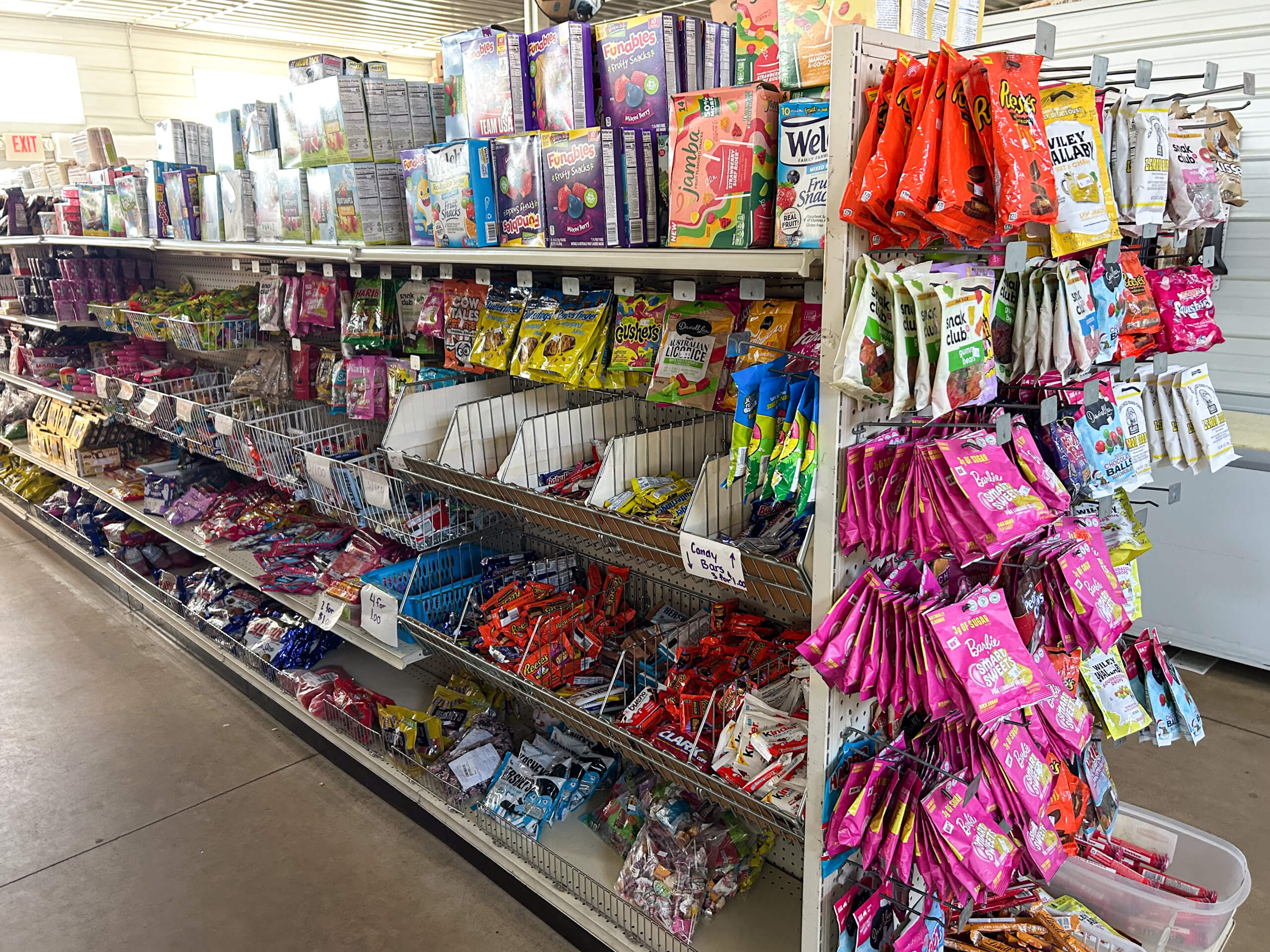 Sunrise Discount Grocery Store Colon MI Shelves stocked with assorted boxes, bags, and packets of candy and snacks in a brightly lit store aisle.