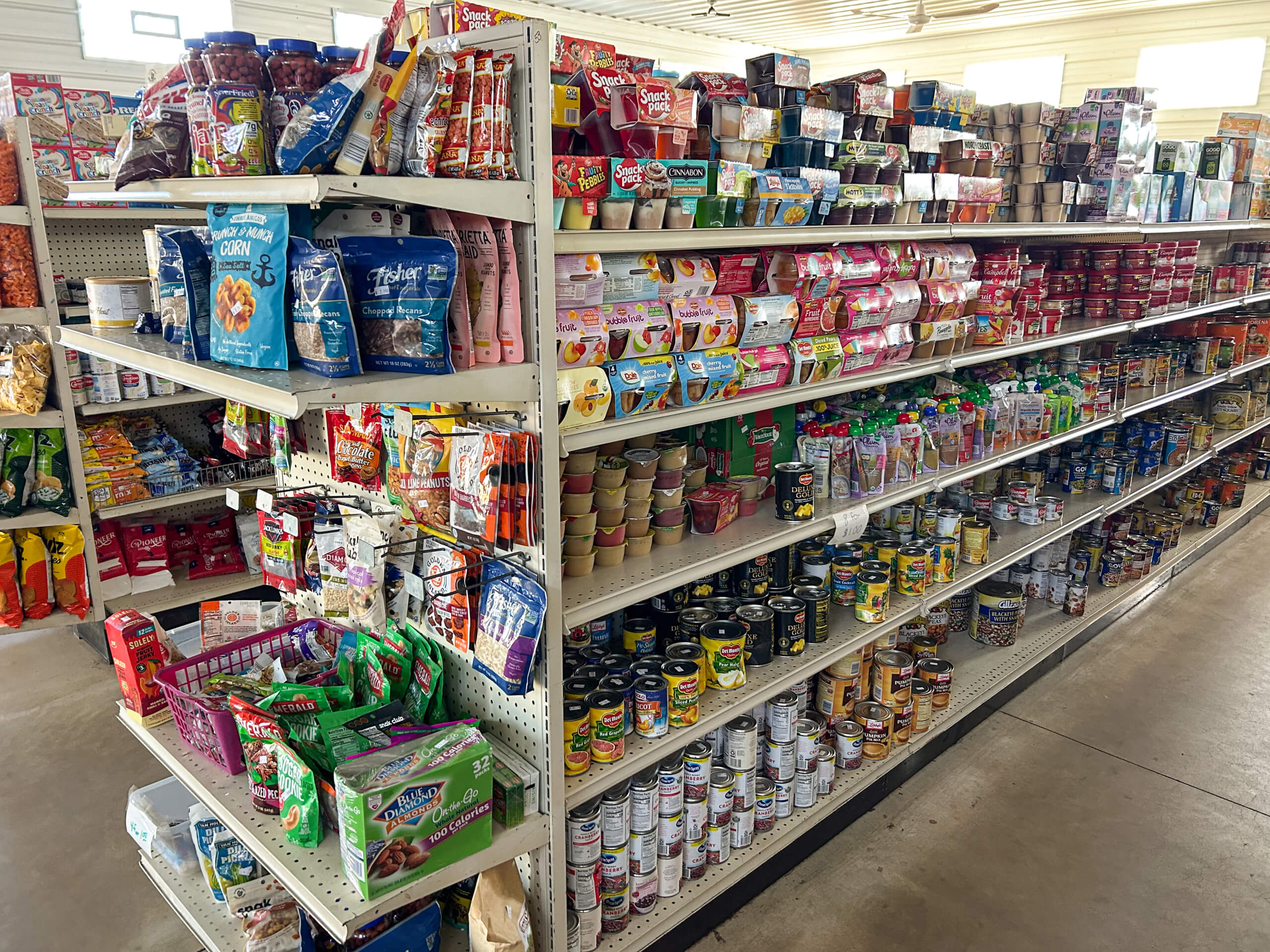 Sunrise Discount Grocery Store Colon MI Grocery store aisle with shelves stocked with canned goods, packaged snacks, and various food items.