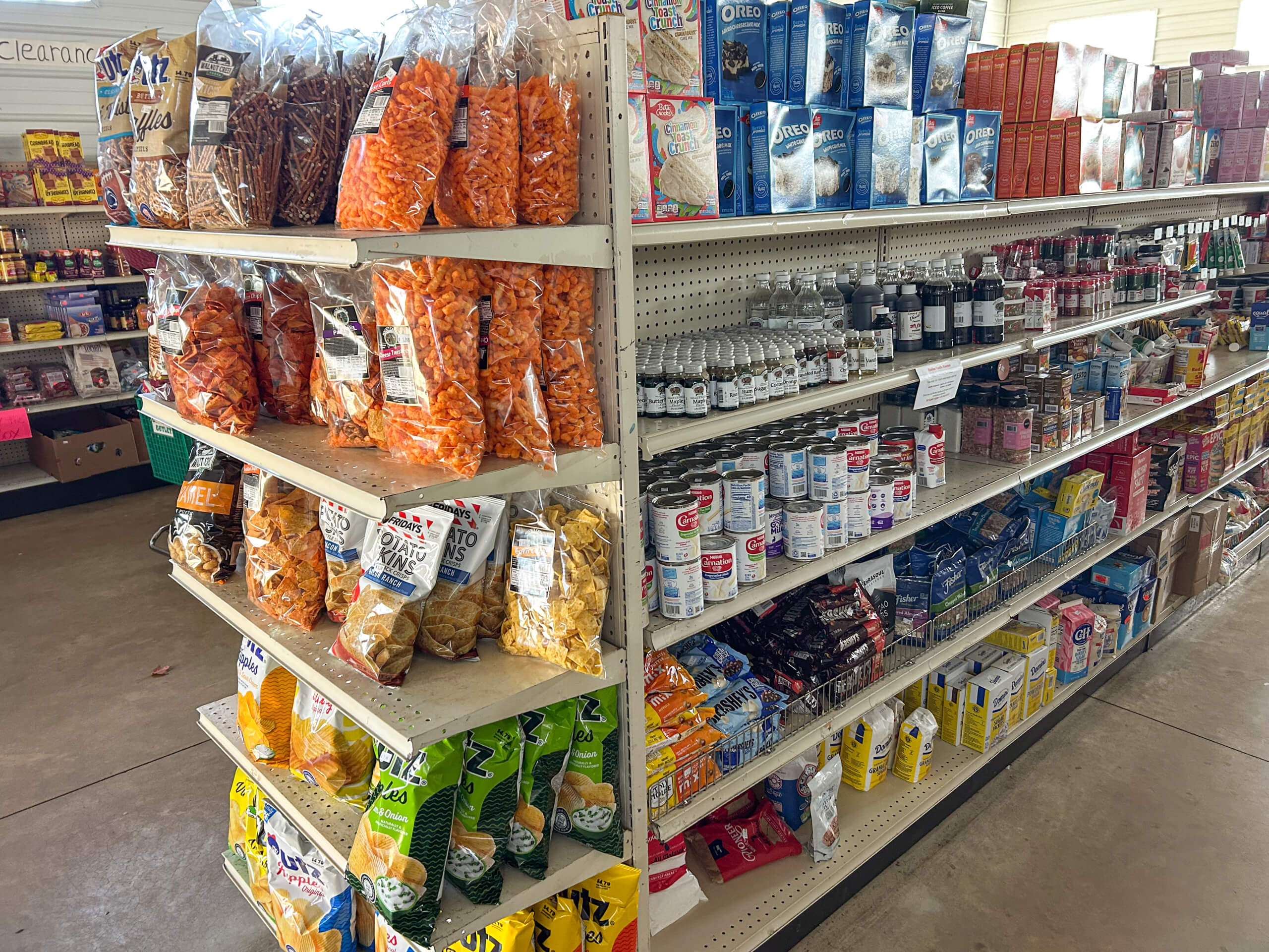 Sunrise Discount Grocery Store Colon MI Grocery store aisle with shelves stocked with assorted chips, snacks, canned goods, baking ingredients, and spices.