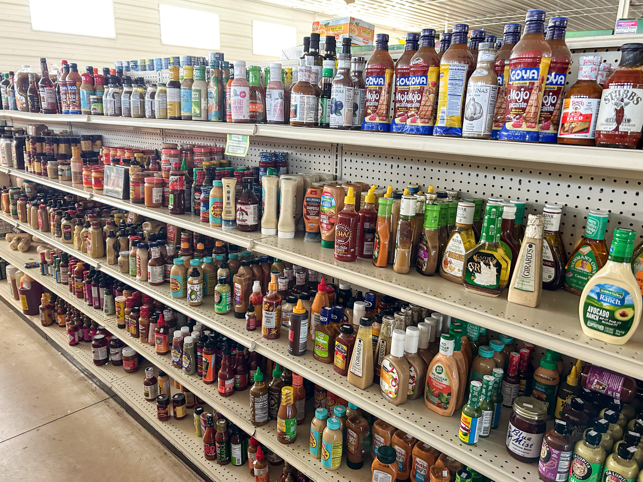 Sunrise Discount Grocery Store Colon MI Shelves in a grocery store aisle stocked with various bottles of sauces, dressings, and condiments, organized by type and brand.