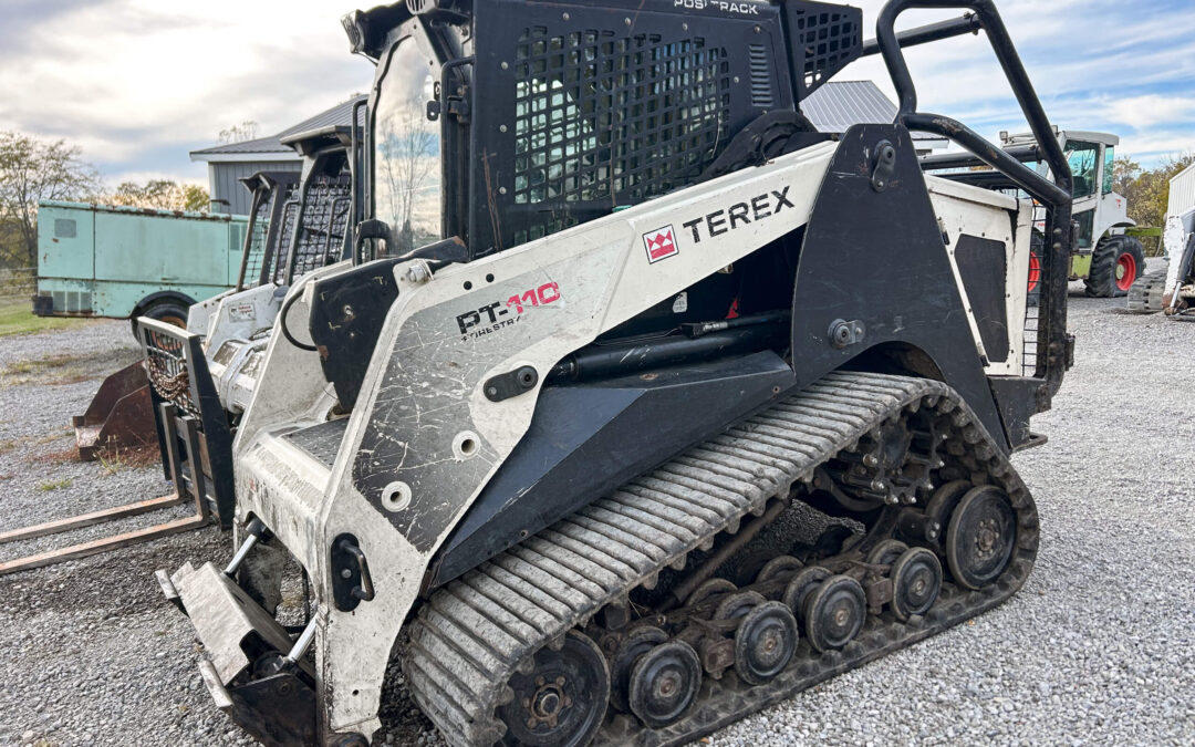 Troyer's Skidloader Repair Rushsylvania, OH A Terex PT-110 compact track loader is parked on gravel, showing its rubber tracks and attachment at the front.