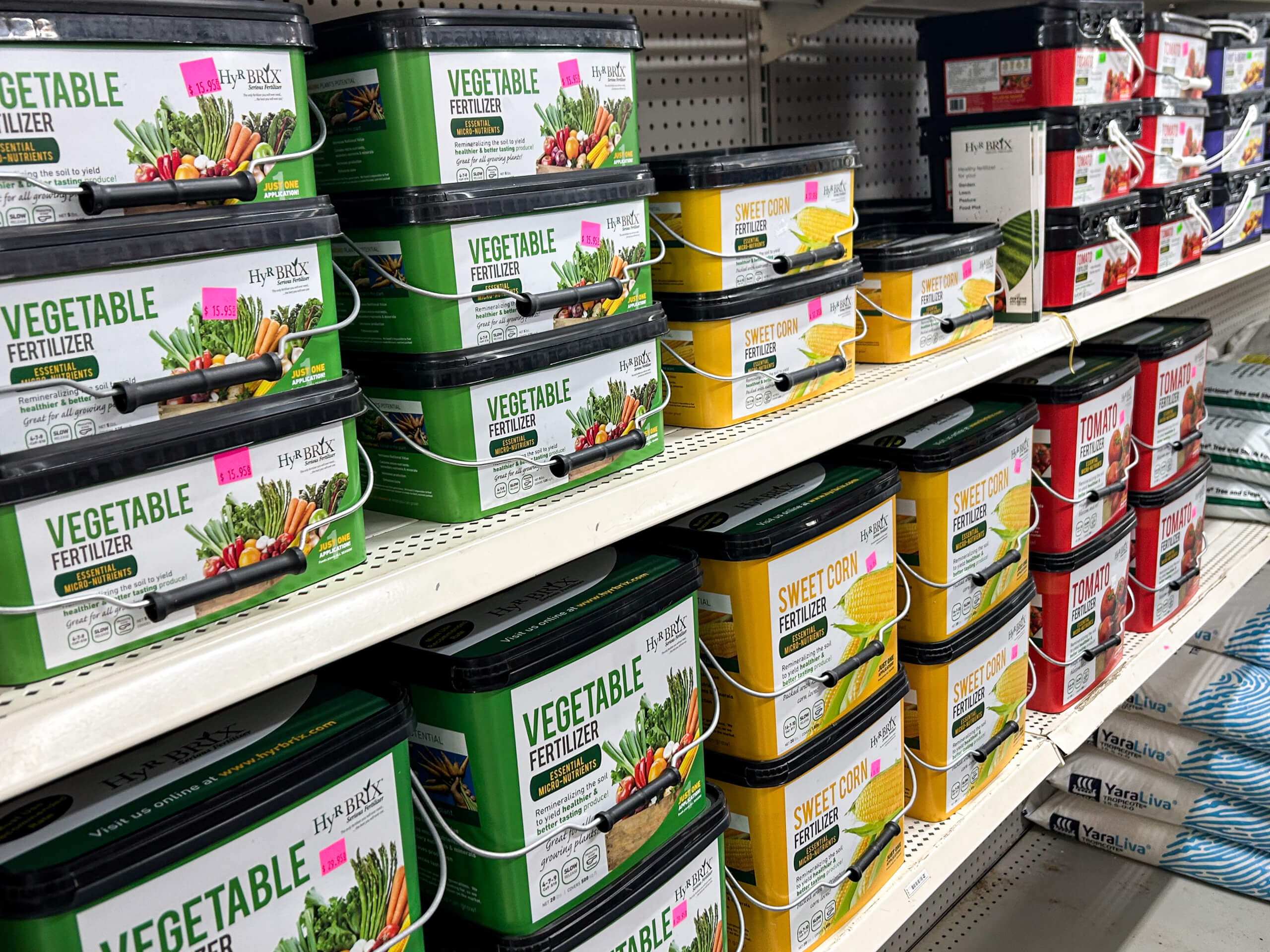 Graber Farm & Home Center Odon Indiana Shelves stocked with containers of vegetable and sweet corn fertilizer in green and yellow packaging at a store.