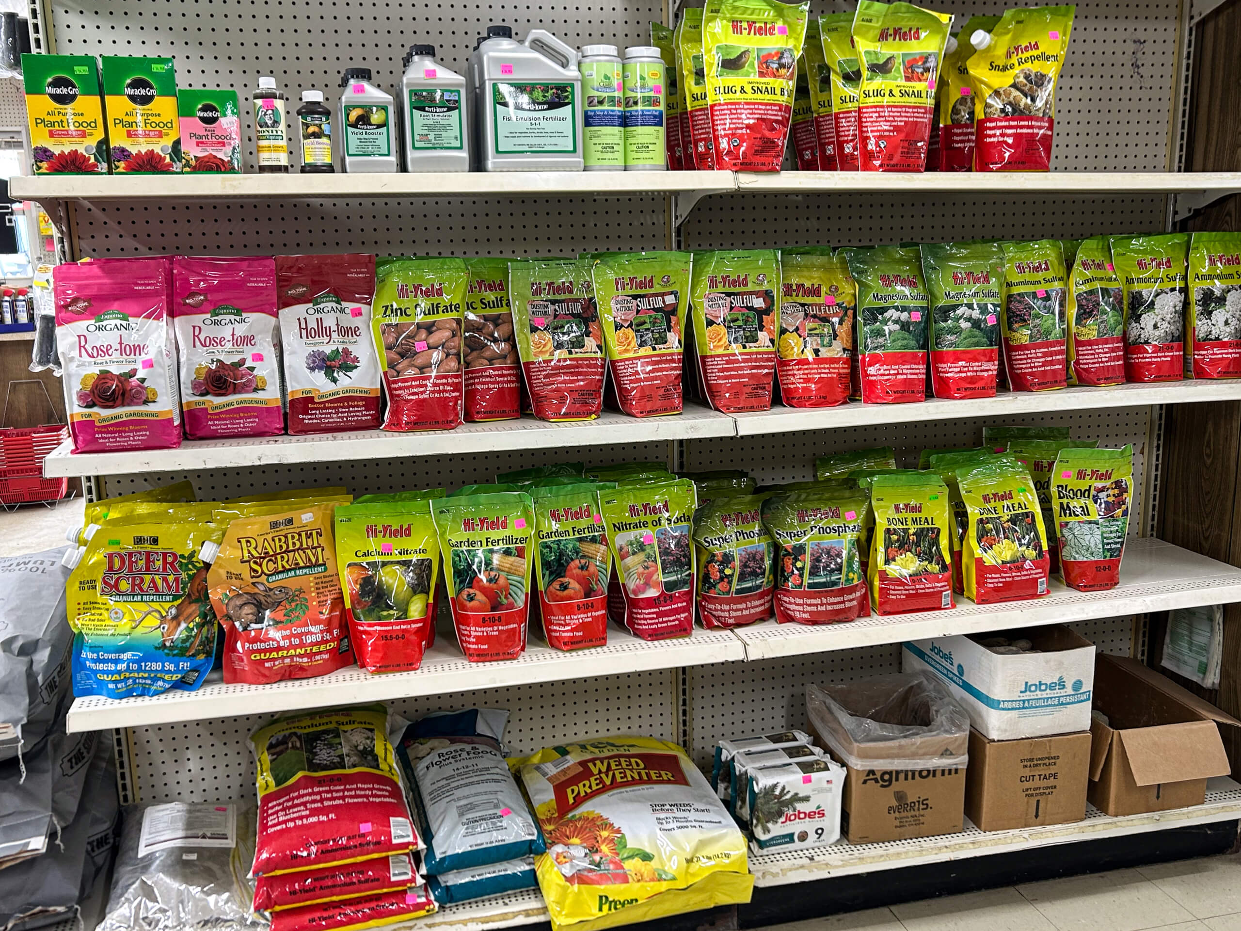 Graber Farm & Home Center Odon Indiana Shelves stocked with various garden fertilizers, plant food, and pest control products in colorful packaging at a store.