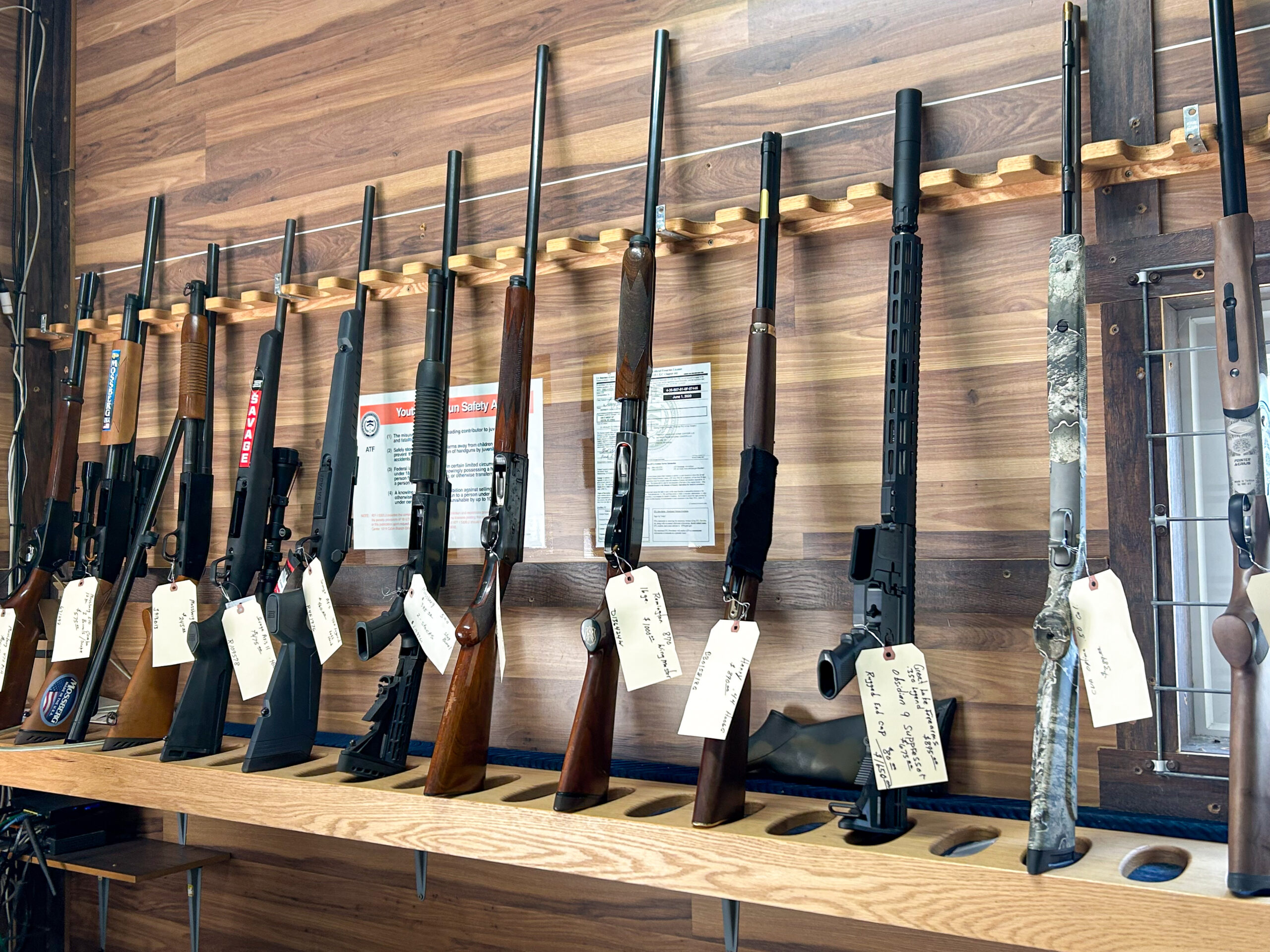 Graber Farm & Home Center Odon Indiana A rack of guns with tags on it.