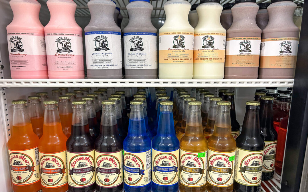 Millcreek Market Junction City Ohio Glass bottles of flavored sodas are arranged on the lower shelves, while plastic bottles of flavored milk are lined up on the top shelf inside a refrigerator display.