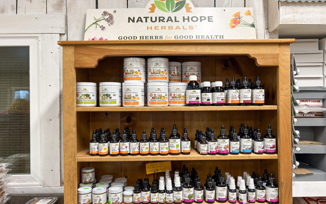 Millcreek Market Junction City Ohio Wooden shelf display of various Natural Hope Herbals products, including tinctures, salves, and powders, organized by type and labeled with a sign reading "Good Herbs for Good Health.