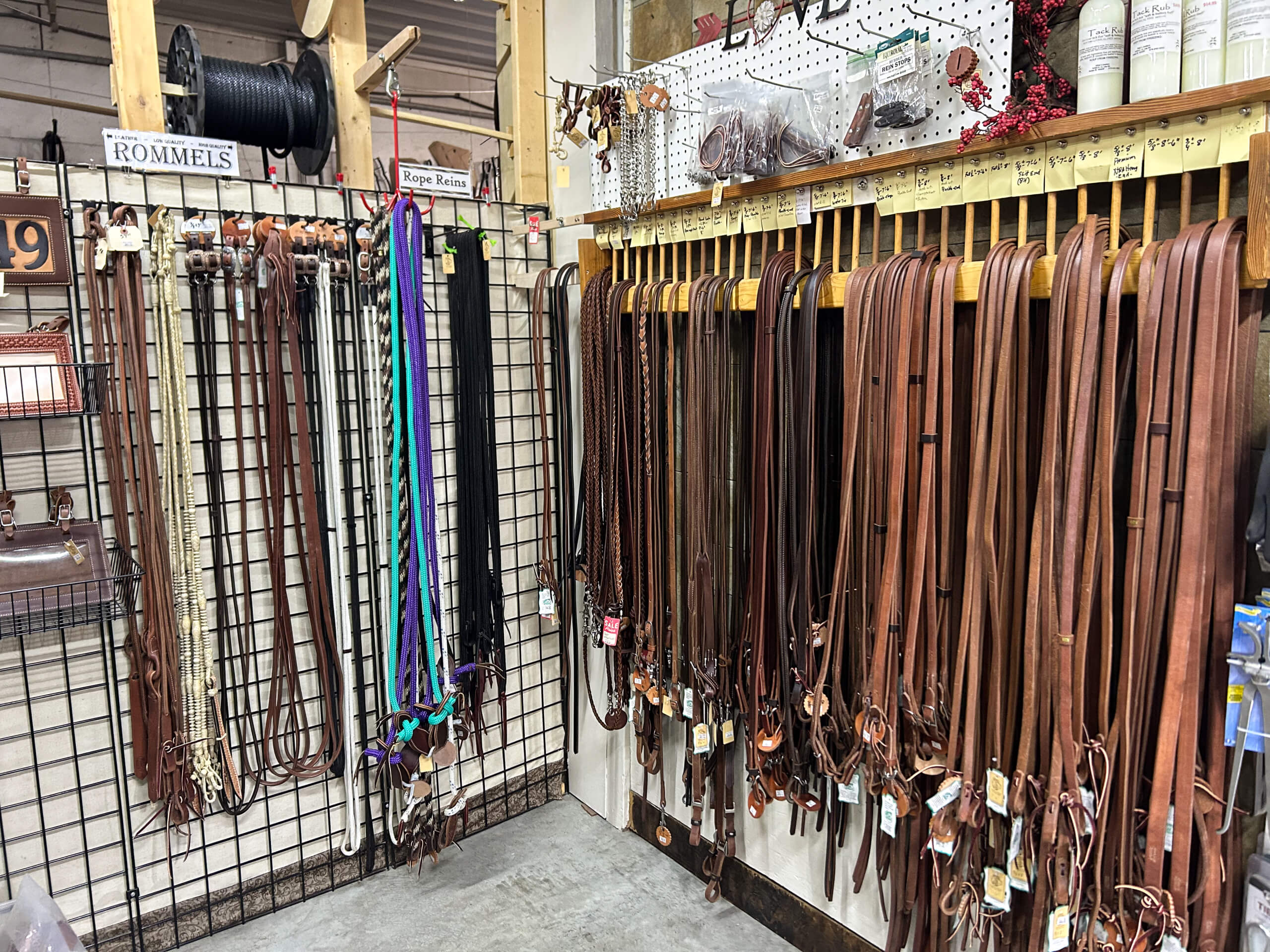 Miller's Saddlery Goshen IN Display of leather horse tack, including reins and straps, hanging on racks in a store specializing in equestrian equipment.