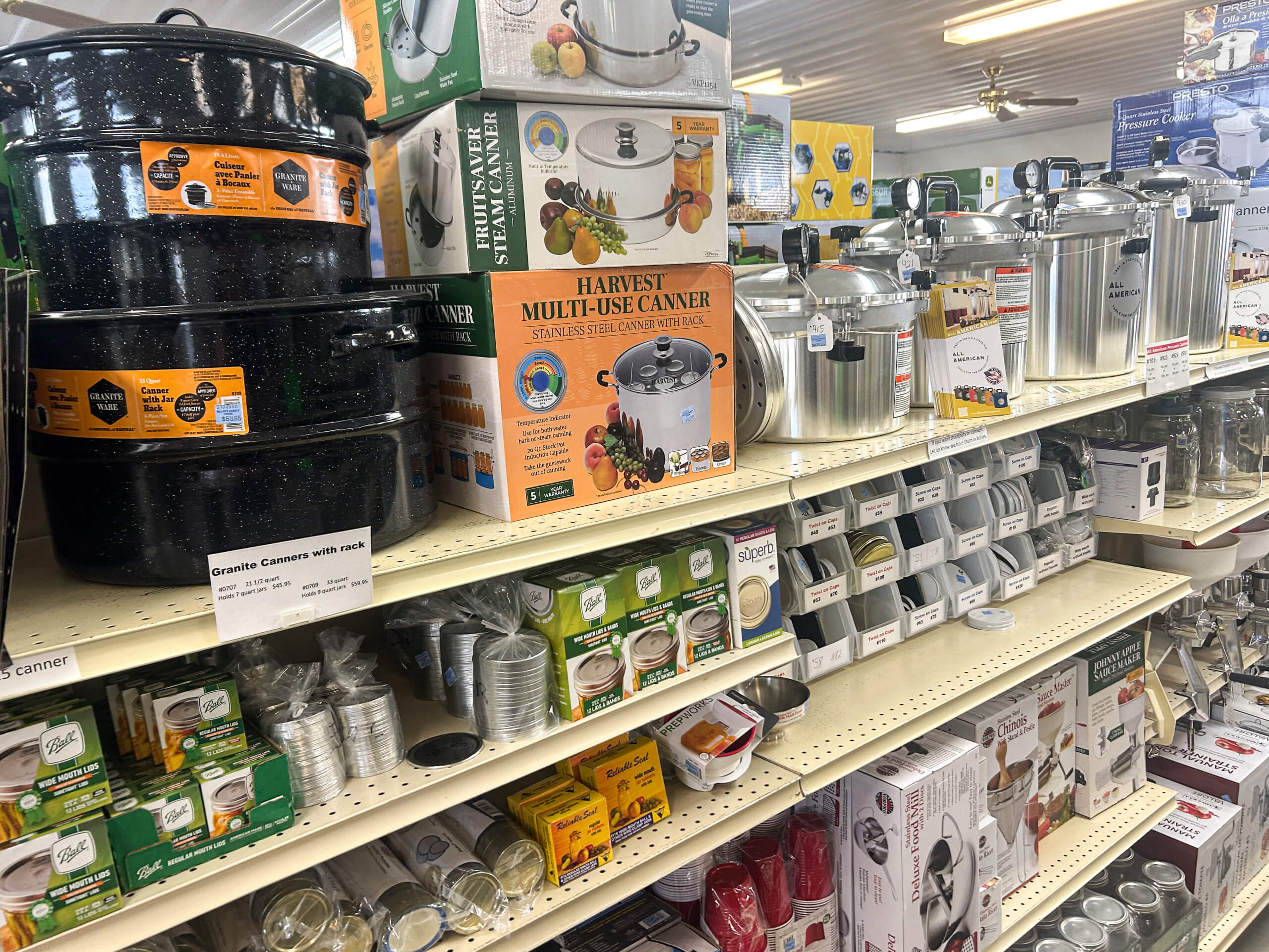 Miller's Variety Store Etna Green, IN Shelves in a store display canners, pressure cookers, jars, lids, and other home canning supplies in various sizes and packaging.