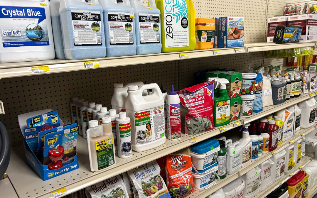 Shetler's Supplies Hardware Variety Bulk Foods Greenville PA Shelves stocked with various gardening supplies, including fertilizers, plant food, pest control products, and ice melt containers in a store aisle.