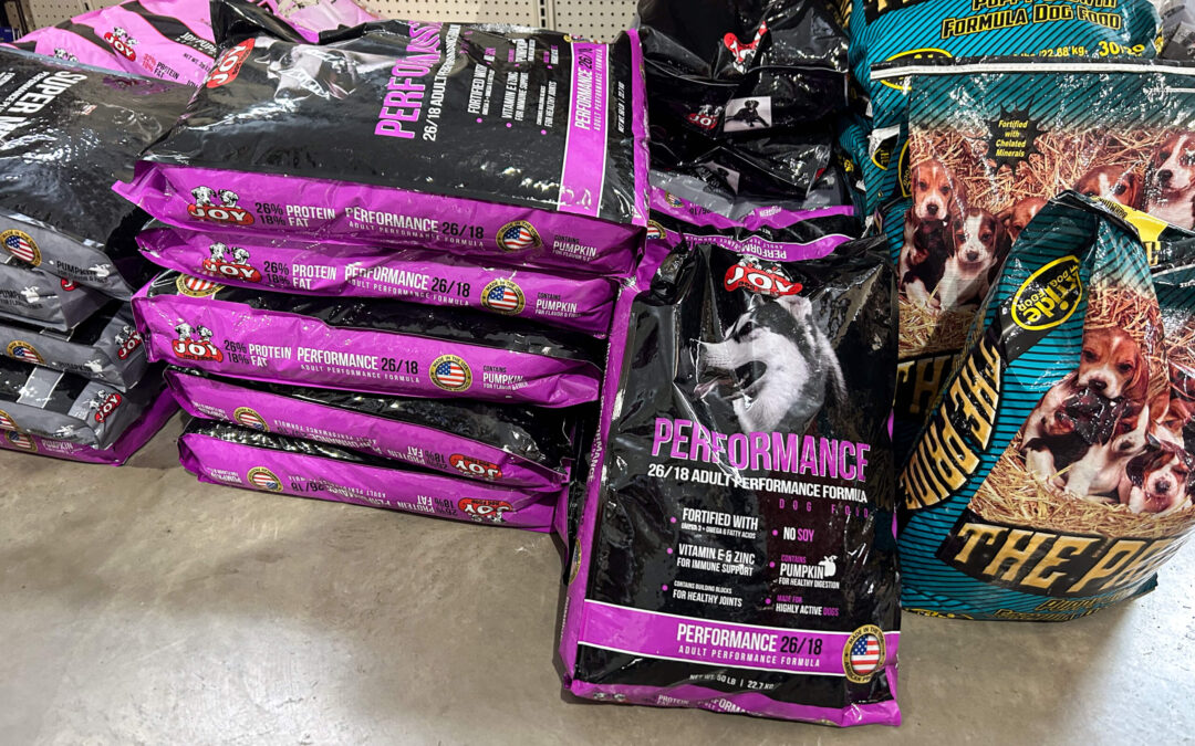 Shetler's Supplies Hardware Variety Bulk Foods Greenville PA Bags of dry dog food labeled "Performance" and "The Pride" are stacked on a store floor display.