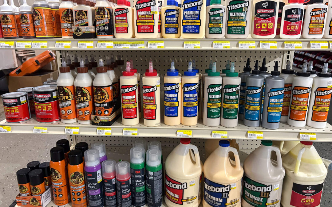 Shetler's Supplies Hardware Variety Bulk Foods Greenville PA Shelves in a store display various brands and sizes of wood glues, adhesives, and sealants, including Gorilla and Titebond products arranged in rows.
