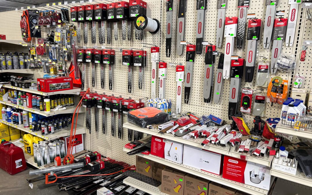 Shetler's Supplies Hardware Variety Bulk Foods Greenville PA A hardware store aisle displays chainsaw bars, chains, oil cans, fuel additives, and assorted tools organized on shelves and hooks.