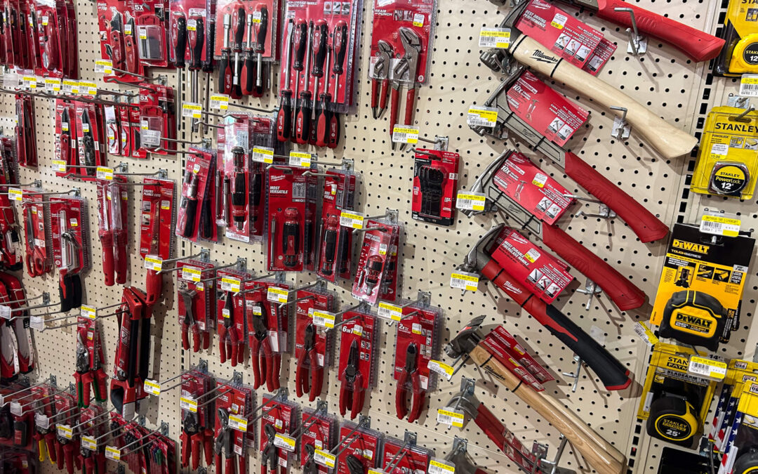 Shetler's Supplies Hardware Variety Bulk Foods Greenville PA A store display of various hand tools, including hammers and tape measures, arranged on a pegboard with red and yellow packaging.